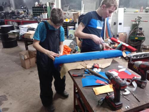 Team members busy building bumpers and developing upholstery skills.